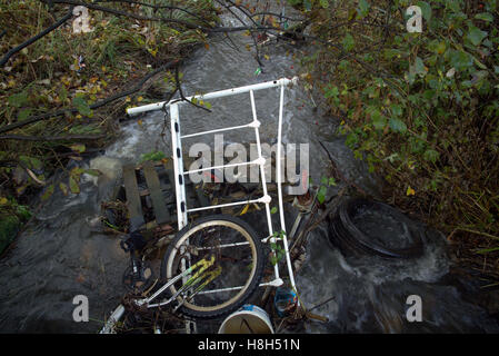 rubbish fly tipped bike in stream or burn Stock Photo