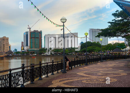 Kuching city waterfront at sunset. People walk on the street. Sarawak. Borneo Malaysia Stock Photo