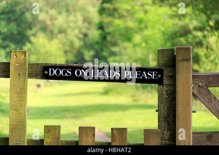 Keep dogs on lead sign fixed to wooden fence rail Stock Photo