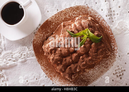 Tiramisu on a plate and espresso coffee on a table close-up. horizontal view from above Stock Photo