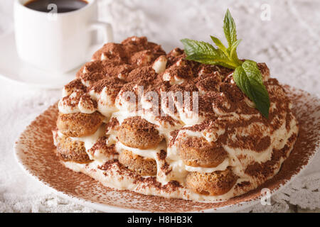 Tasty tiramisu on a plate and espresso coffee on a table close-up. Horizontal Stock Photo