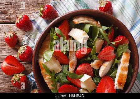 Dietary salad with strawberries, grilled chicken, brie and arugula close-up on the table. horizontal view from above Stock Photo