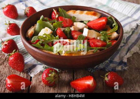 Dietary salad with strawberries, grilled chicken, brie and arugula close-up on the table. Horizontal Stock Photo