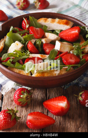Summer salad with strawberries, grilled chicken, brie and arugula close-up on the table. vertical Stock Photo