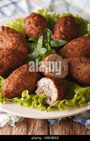 Arabic food kibbeh with bulgur and pine nuts on a plate macro. vertical Stock Photo