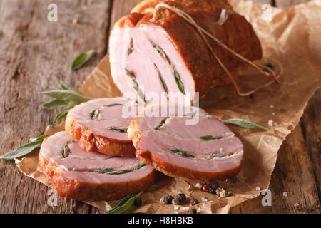 Baked Roll of pork stuffed with sage close up on the table. horizontal Stock Photo