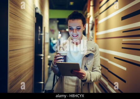 Brunette woman using tablet after work Stock Photo