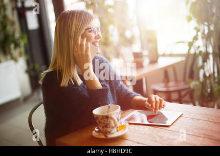 Busy businesswoman multitasking, drinking coffee talking on phone and surfing Stock Photo