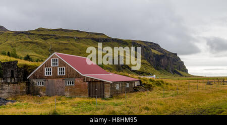 Farm house nestled into the mountainside in South Iceland Stock Photo