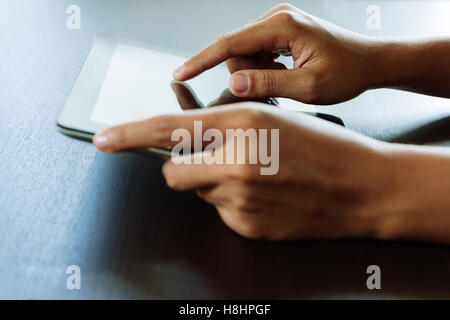 close-up hand using tablet, selective focus finger touching on tablet display Stock Photo