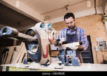 Framing contractor using a circular cut off saw to trim wood studs length. Stock Photo