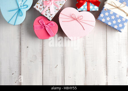 Gift boxes of different patterns and shapes on white wooden background Stock Photo