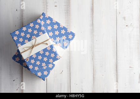Gift boxes with floral patterns on white wooden background Stock Photo