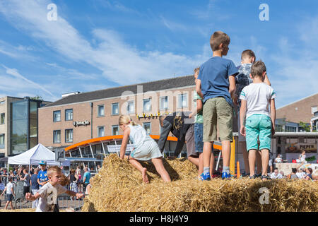 Kids playing at hay bales on an agricultural potato festival in Emmeloord, the Netherlands Stock Photo