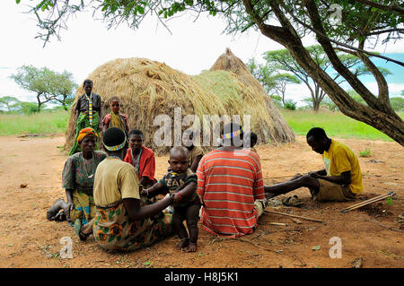 Hadzabe people in front of their thatch made hut Stock Photo