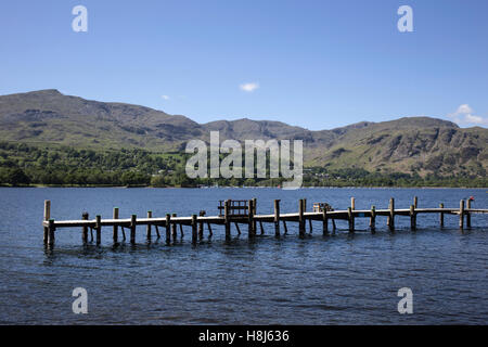 Wooden boat jetty on Lake Coniston. Coniston Old Man, viewed from Brantwood, home of John Ruskin in the English Lake District Stock Photo