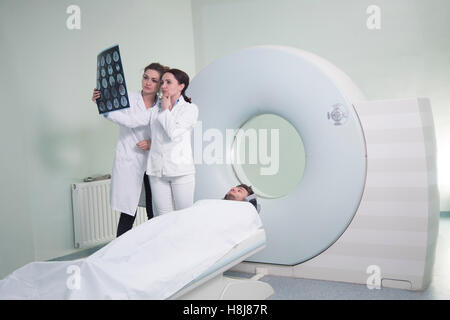 Radiologic technician and Patient being scanned and diagnosed on scanner
