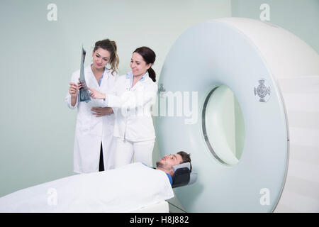 Radiologic technician and Patient being scanned and diagnosed on scanner
