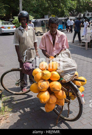 Bicycle coconut vendor iselling to a customer in Sri Lanka, Stock Photo