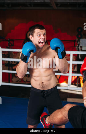 Muscular fighter with an angry face on a ring. Stock Photo