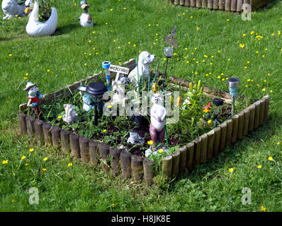 lawn ornaments on grass surrounded by wooden edge Stock Photo
