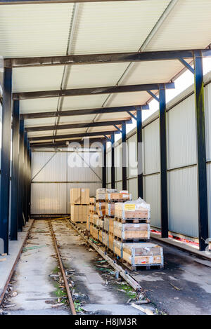 Brakne Hoby, Sweden - October 29, 2016: Documentary of local industrial area. Outdoor storage area under roof. Wooden pallets ar Stock Photo