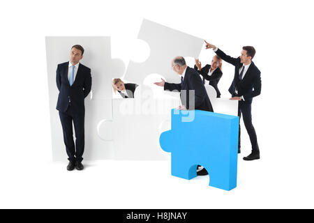 Lazy businessman and business team working concept, people assembling puzzle isolated on white Stock Photo