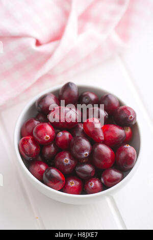 The tasty american cranberries in bowl on white table. Stock Photo