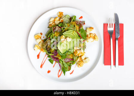 Freshly prepared salad with avocado and halloumi, top down view, isolated on white Stock Photo