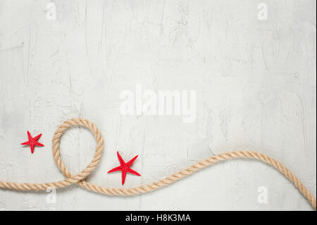 Rope and two starfishes on the light textured background with empty space Stock Photo