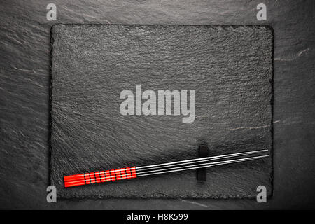 Two chopsticks on black stone background with copyspace, top view Stock Photo
