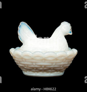 Glass hen sitting on her eggs / chicks against black background Stock Photo