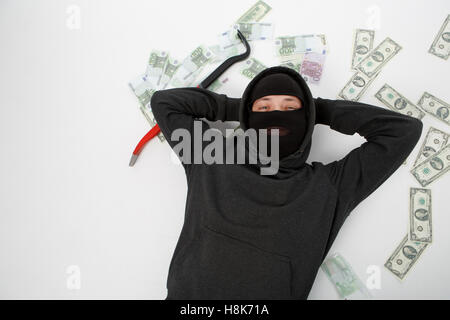 Satisfied burglar lies on floor Stock Photo