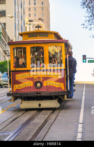 SAN FRANCISCO, USA - DECEMBER 16: Passengers enjoy a ride in a cable car on Dec 16, 2013 in San Francisco. It is the oldest mech Stock Photo