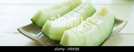 Juicy slice cantaloupe melon on ceramic dish Stock Photo