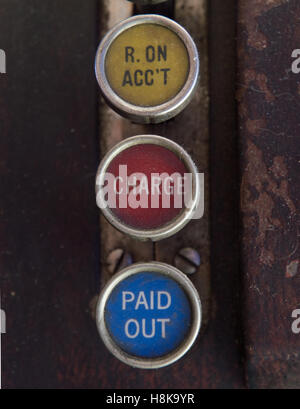 Close up of antique wooden cash register with three keys labeled paid out, charge, and r on acc't  (received on account). Stock Photo