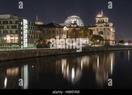 Berlin, Germany. 12th Nov, 2016. The lights of the German Reichstag building and the Bundestag next to it shine bright and throw shimmering reflections upon the river spree in Berlin, Germany, 12 November 2016. Photo: Paul Zinken/dpa/Alamy Live News Stock Photo