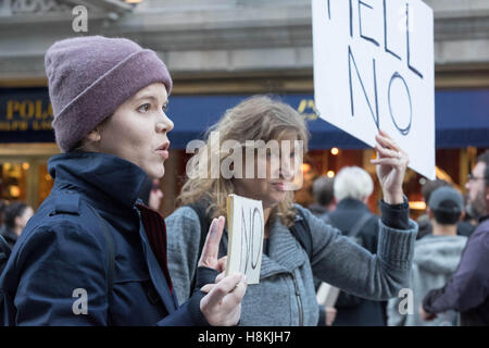New York, USA. 13th November, 2016. Two women hold up placards, and one woman flashes the peace sign, during a peaceful protest on 5th Avenue near the Trump Tower in New York City. Credit:  barbara cameron pix/Alamy Live News Stock Photo