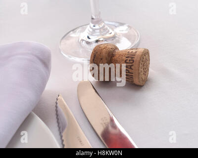 CHAMPAGNE CORK Luxury dining table setting with champagne reflection and vintage rosé champagne cork on tablecloth Stock Photo