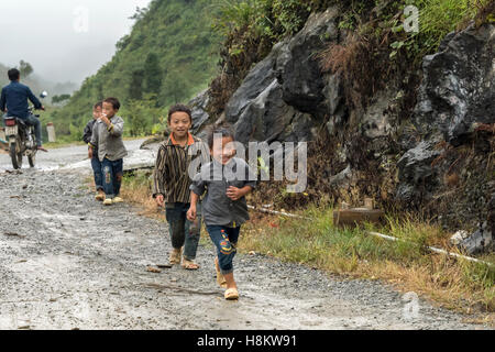 Country boys running in a light rain, near Sa Pa, north Vietnam Stock Photo