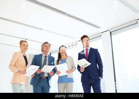 Business people holding documents while looking away in new office Stock Photo