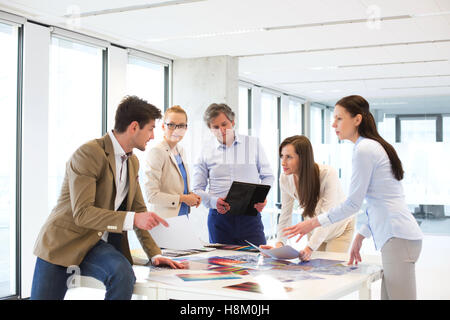 Male and female design professionals having discussion at table in new office Stock Photo
