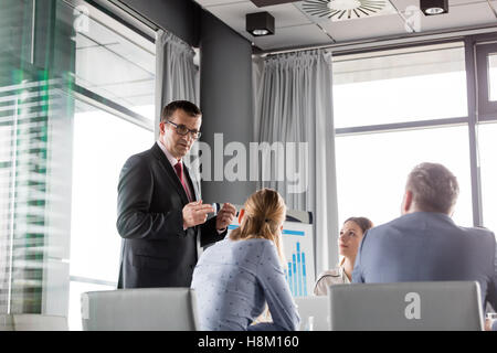 Mature businessman discussing with colleagues in board room Stock Photo