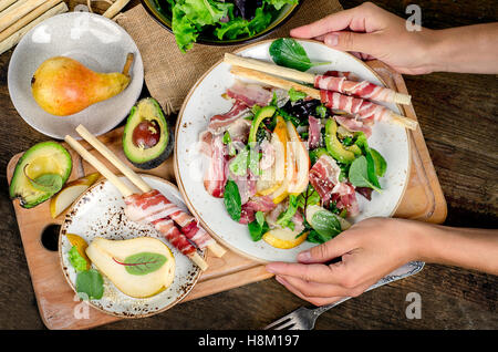Woman hands holding plate with fresh salad. Top view Stock Photo