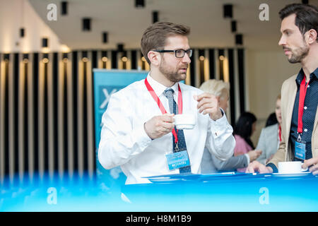 Businessmen talking during coffee break at lobby of convention center Stock Photo