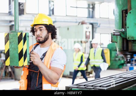 Young manual worker operating machinery in metal industry Stock Photo