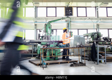 Manual worker operating machinery at metal industry Stock Photo