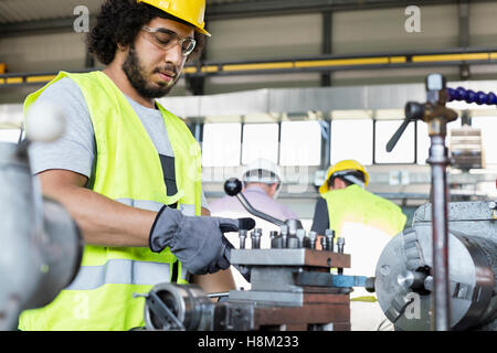 Young manual worker operating machinery in metal industry Stock Photo