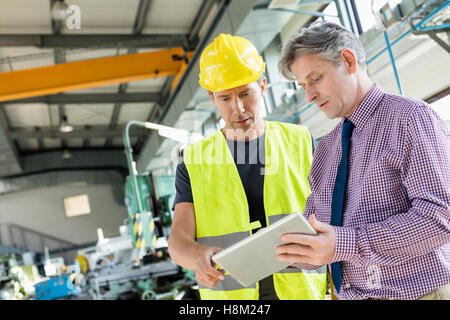 Supervisor and manual worker using digital tablet in metal industry Stock Photo