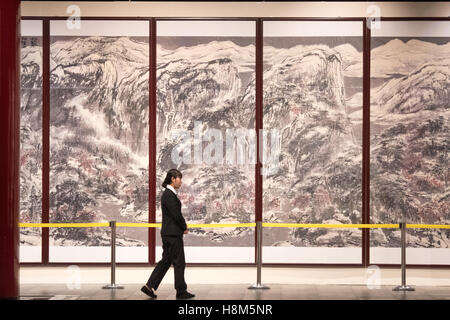Beijing China - Chinese man in a suit walking past ancient paintings and artifacts inside the Palace Museum located in the Forbi Stock Photo